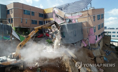 서울 동작구 서울상도유치원이 지반 불안으로 기울어지는 사고가 난 지 나흘째인 9일 오후 관계자들이 철거작업을 하고 있다. <연합뉴스>